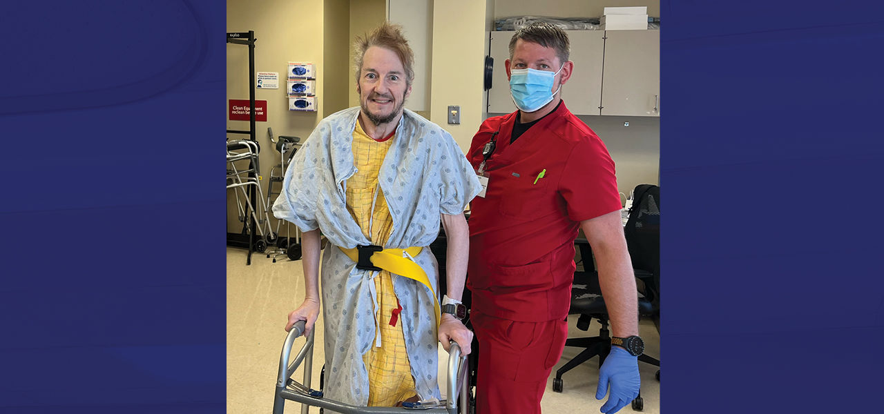 Cornerstone Specialty Hospital Little Rock patient Andrew stands and poses with his caregiver
