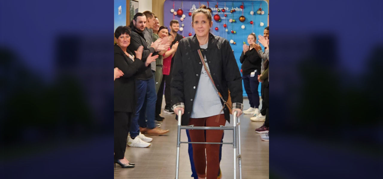 Cornerstone Specialty Hospital Broken Arrow patient Aubree walks out of the hospital while her care team lines the hallway